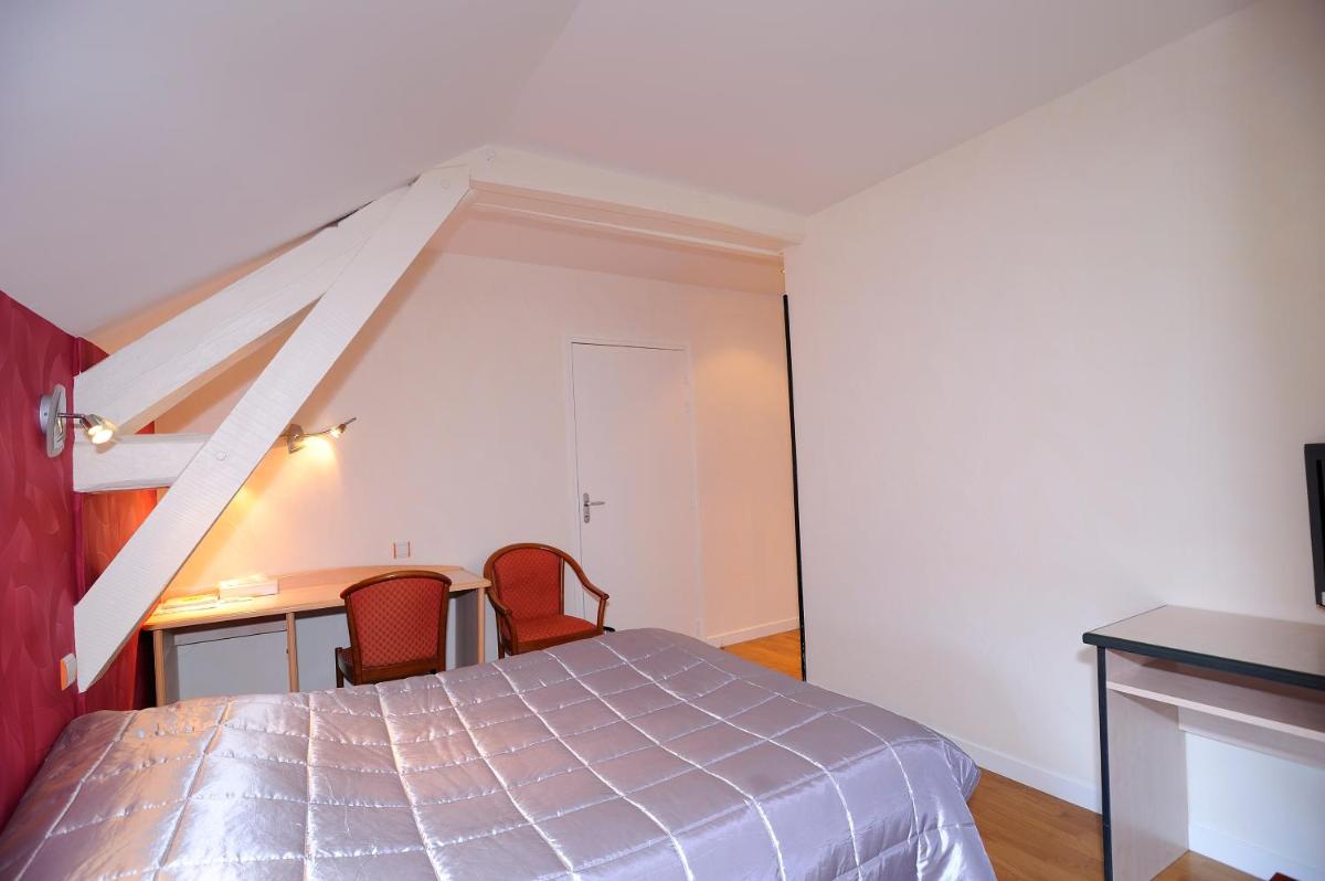 Un ou plusieurs lits dans un hébergement de l'établissement Logis Hôtel Restaurant Aux Maisons