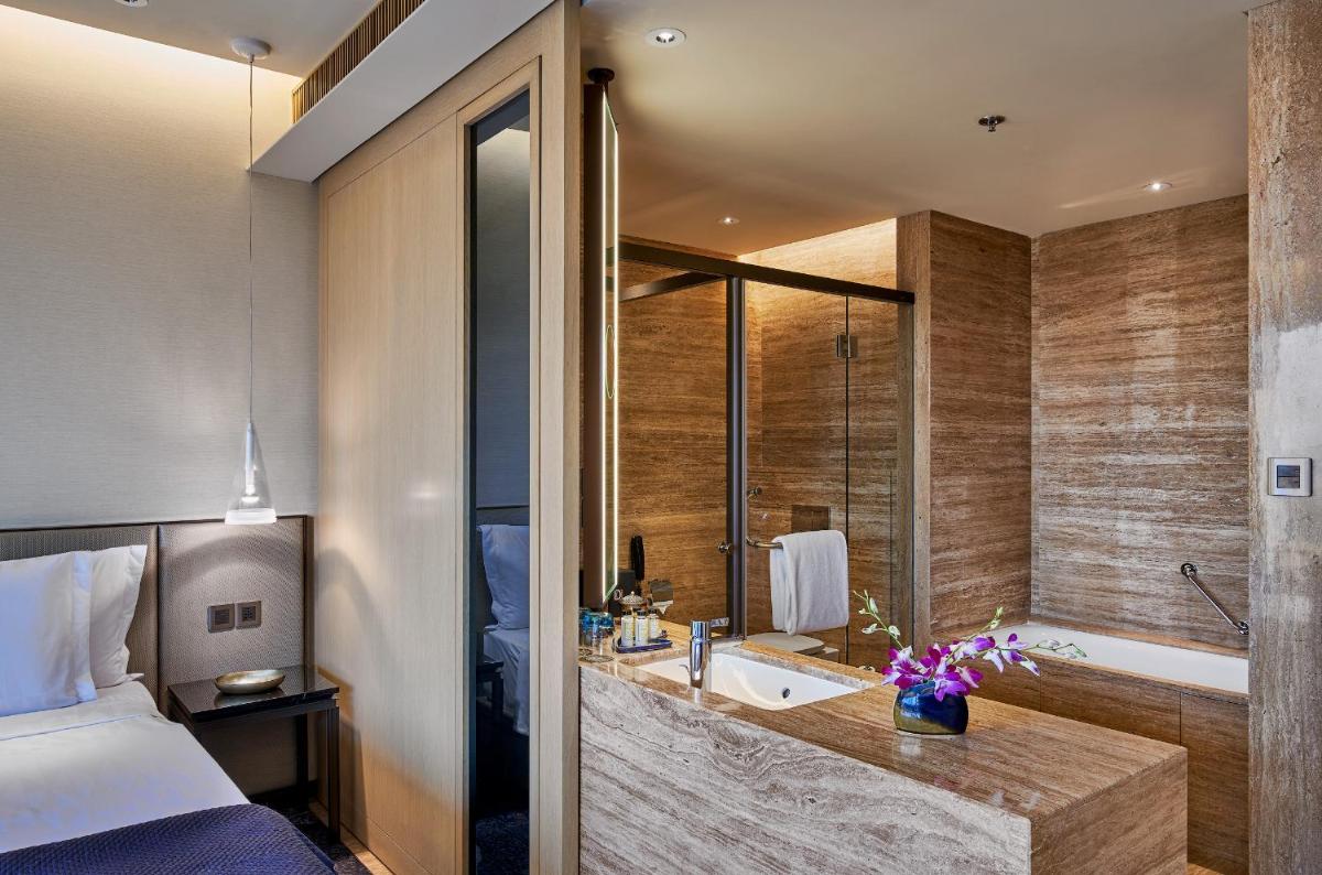 a bathroom with a bed and a tub and a sink at The Den, Bengaluru in Bengaluru a bathroom with a bed and a tub and a sink at The Den, Bengaluru in Bengaluru