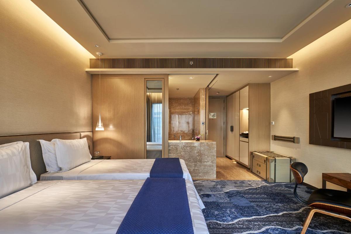 a hotel room with a bed and a television at The Den, Bengaluru in Bengaluru +54 photos