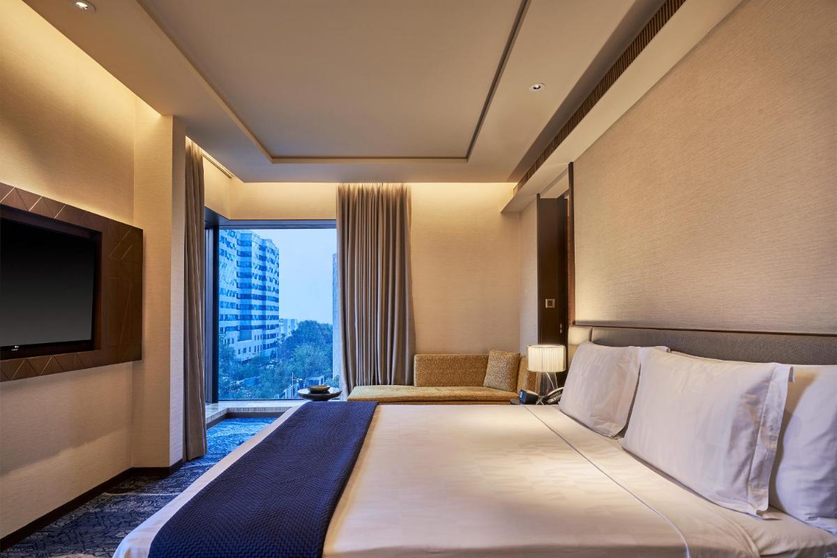 a hotel room with a large bed and a large window at The Den, Bengaluru in Bengaluru
