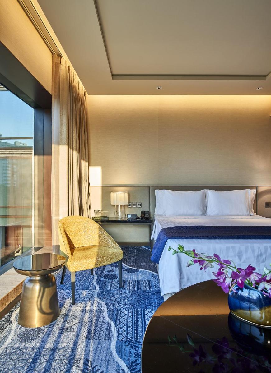a hotel room with a bed and a table at The Den, Bengaluru in Bengaluru