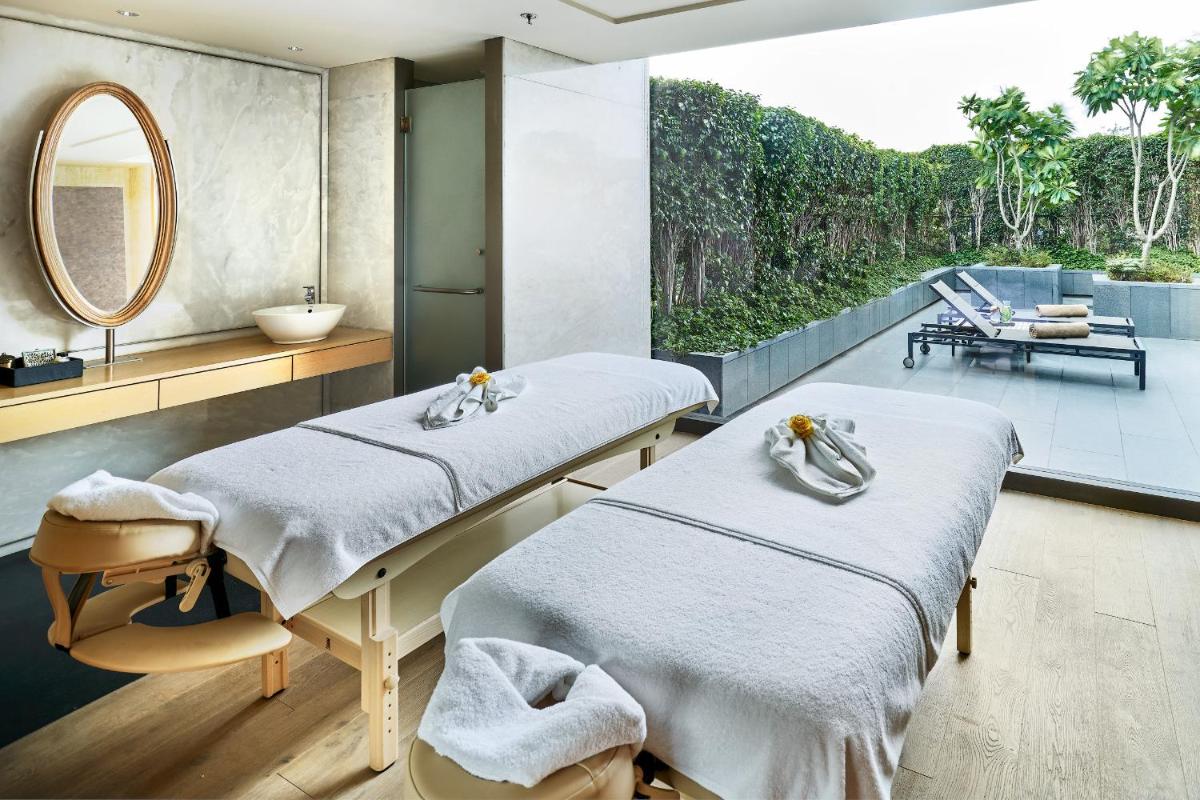 two beds in a room with a mirror at The Den, Bengaluru in Bengaluru