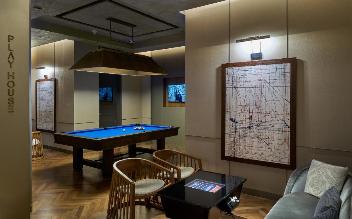 a game room with a pool table and a couch at The Den, Bengaluru in Bengaluru