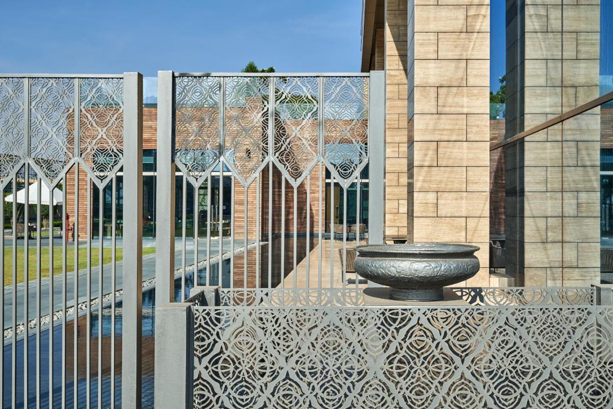 a metal fence with a fountain in front of a building at The Den, Bengaluru in Bengaluru