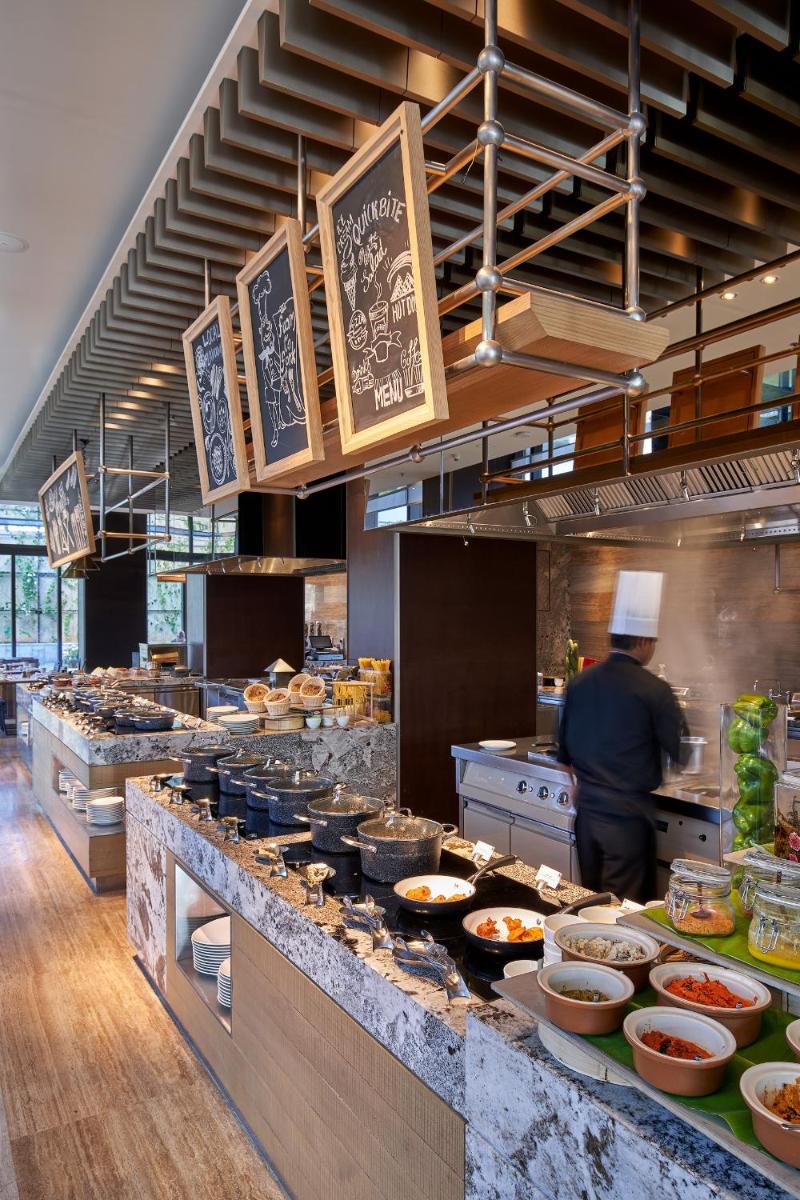 a chef preparing food in a restaurant kitchen at The Den, Bengaluru in Bengaluru