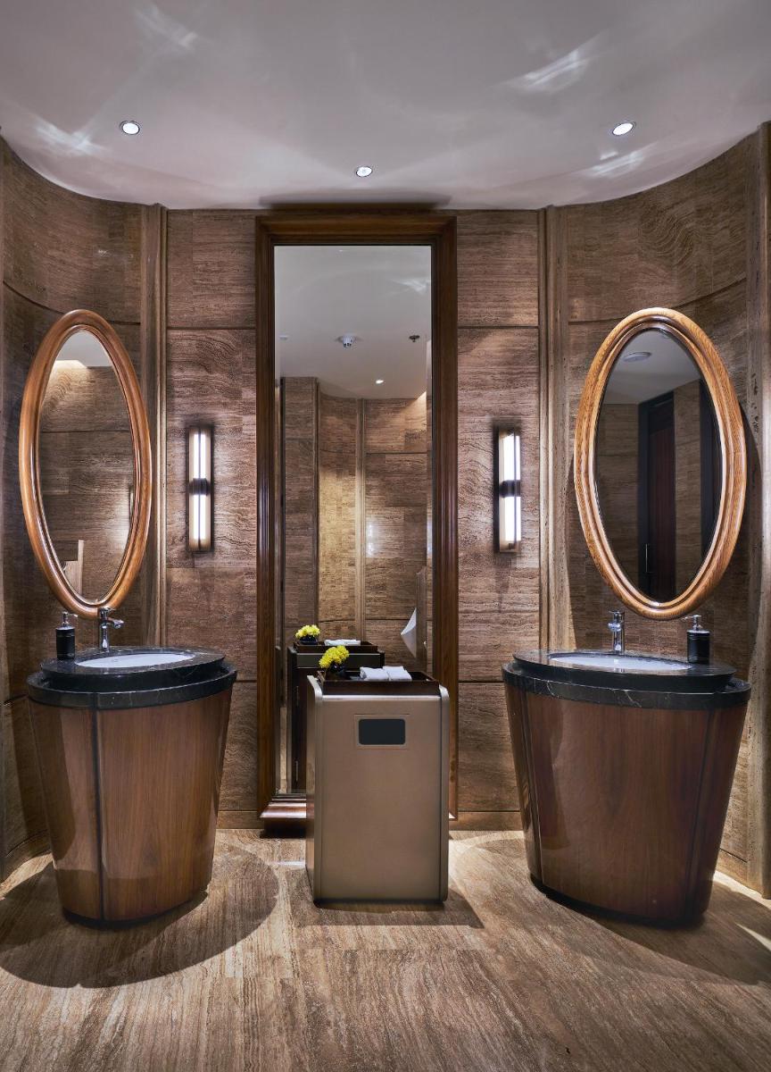 a bathroom with two sinks and two mirrors at The Den, Bengaluru in Bengaluru