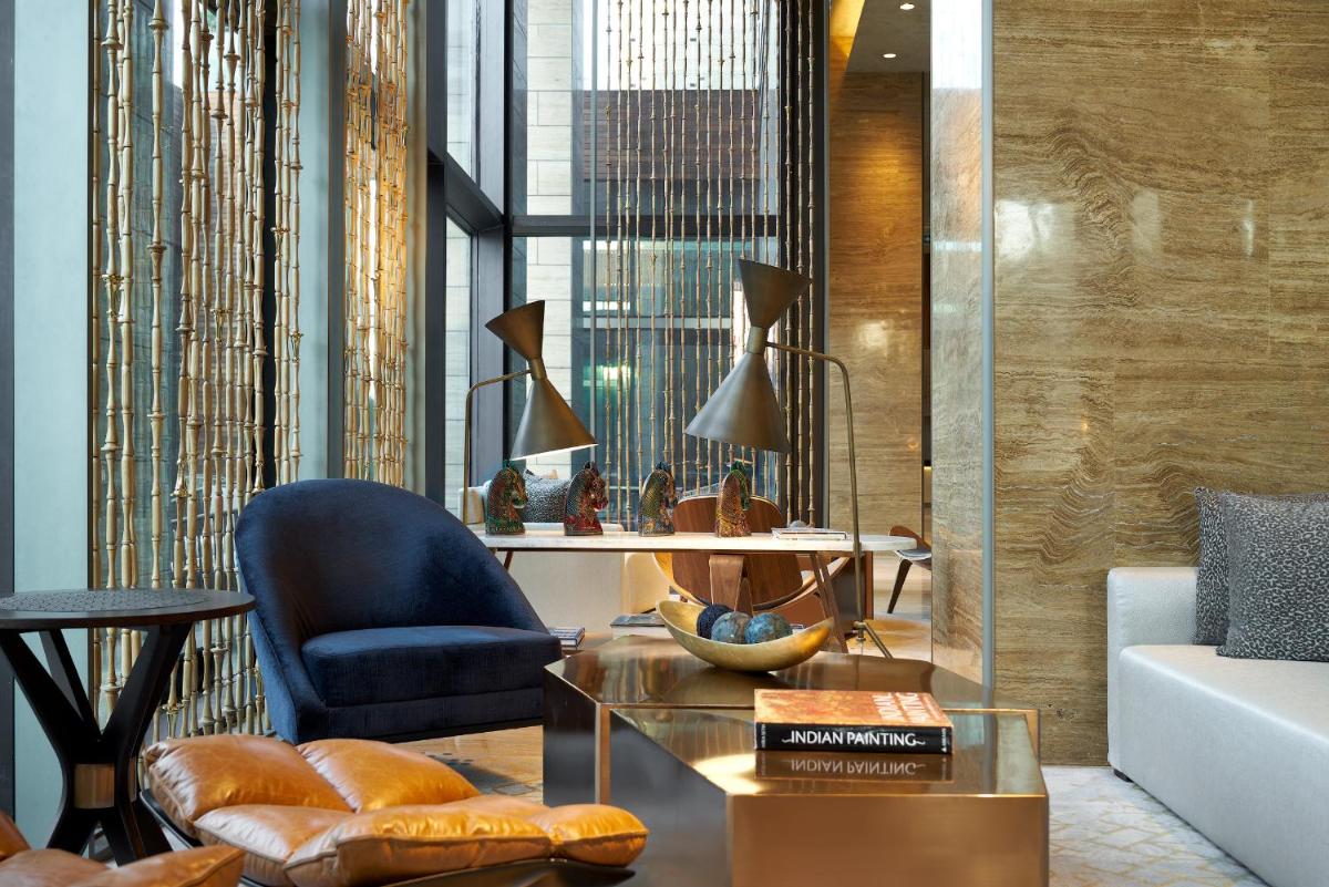 a living room with a chair and a glass table at The Den, Bengaluru in Bengaluru