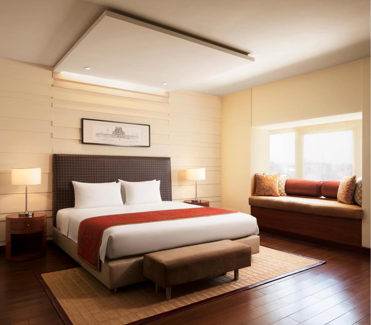 a bedroom with a large bed and a couch at Taj Coromandel in Chennai