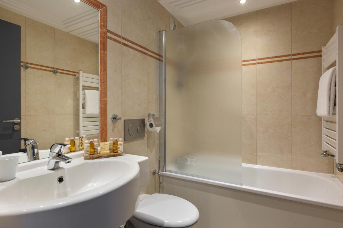 une salle de bain avec un lavabo, une douche et des toilettes dans l'établissement Araucaria Hotel & Spa, à La Plagne