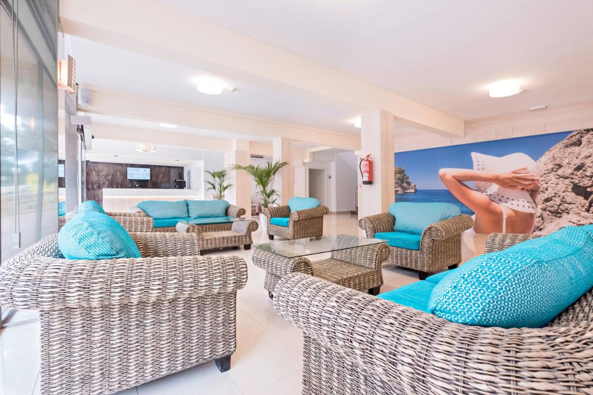 Una sala de estar con sillas de mimbre y almohadas azules. en azuLine Hotel Bahamas y Bahamas II, en El Arenal