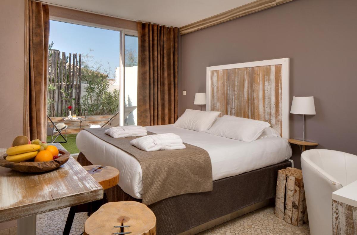 une chambre avec un grand lit et un balcon dans l'établissement Vila De La Mar & Spa, à Saintes-Maries-de-la-Mer