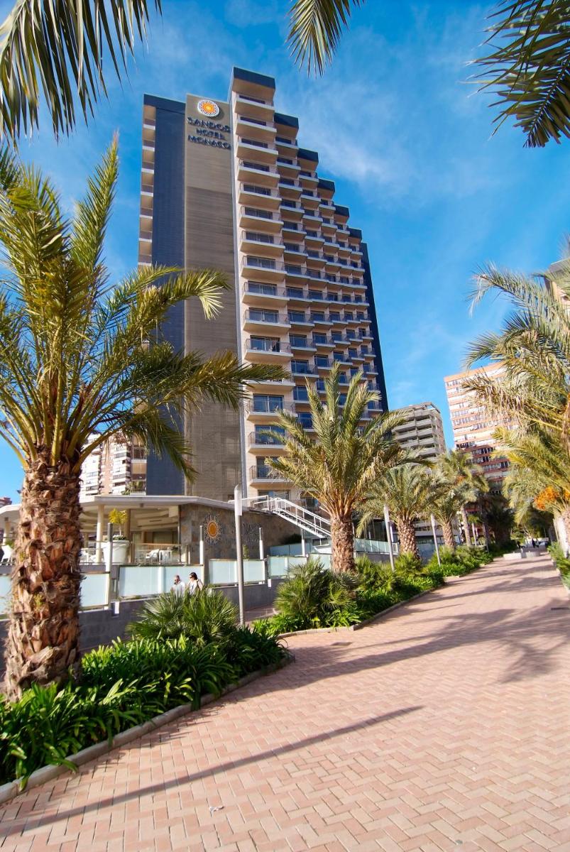 Un edificio alto con palmeras delante. en Sandos Monaco - Adults Only, en Benidorm