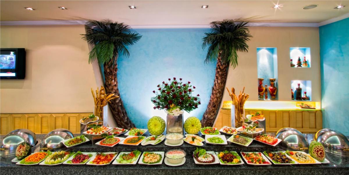 a table full of food with palm trees in the background at The Piccadily in Lucknow