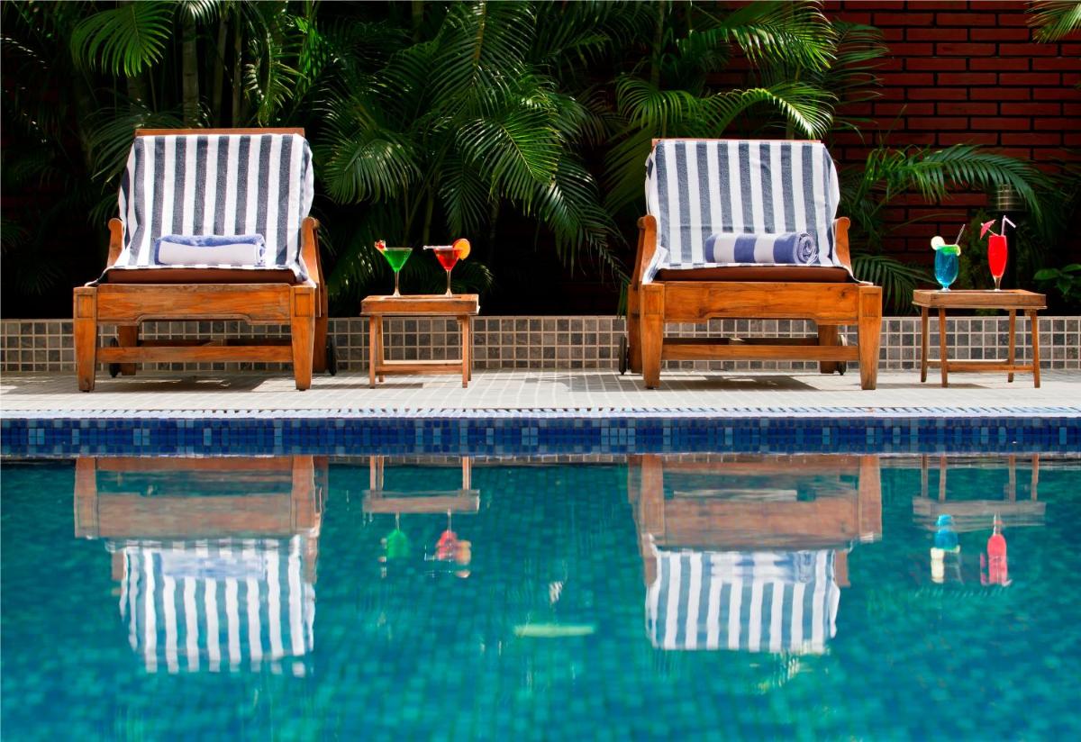 two chairs sitting next to a swimming pool at The Piccadily in Lucknow