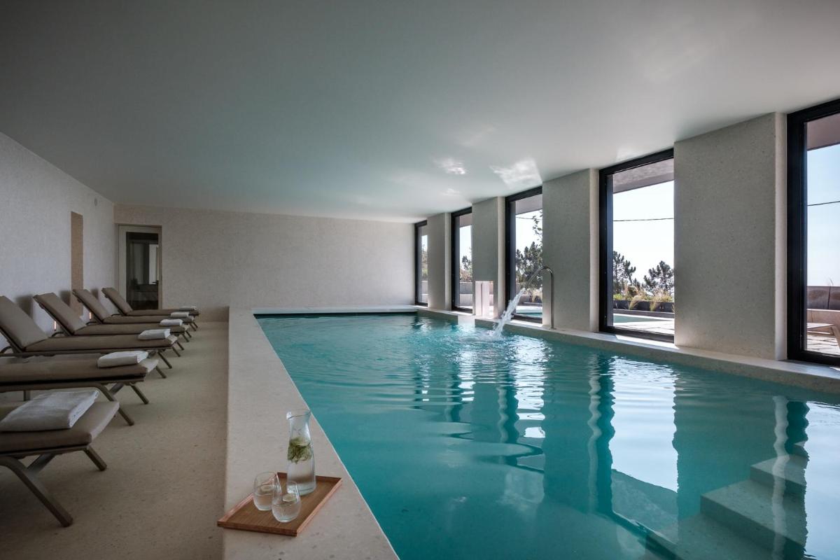 uma piscina em um prédio com janelas em Casa de São Lourenço - Burel Panorama Hotel - member of Design Hotels em Manteigas