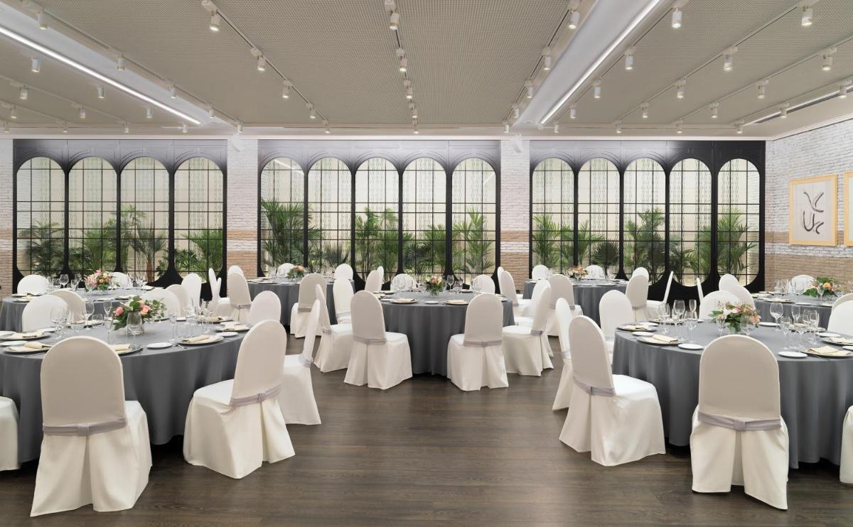 un salón de banquetes con mesas y sillas blancas en H10 Marina Barcelona, en Barcelona 79 fotos más