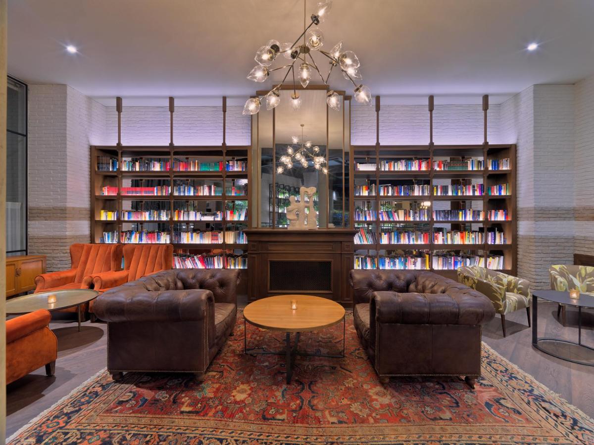 biblioteca con sofás, chimenea y estanterías en H10 Marina Barcelona, en Barcelona