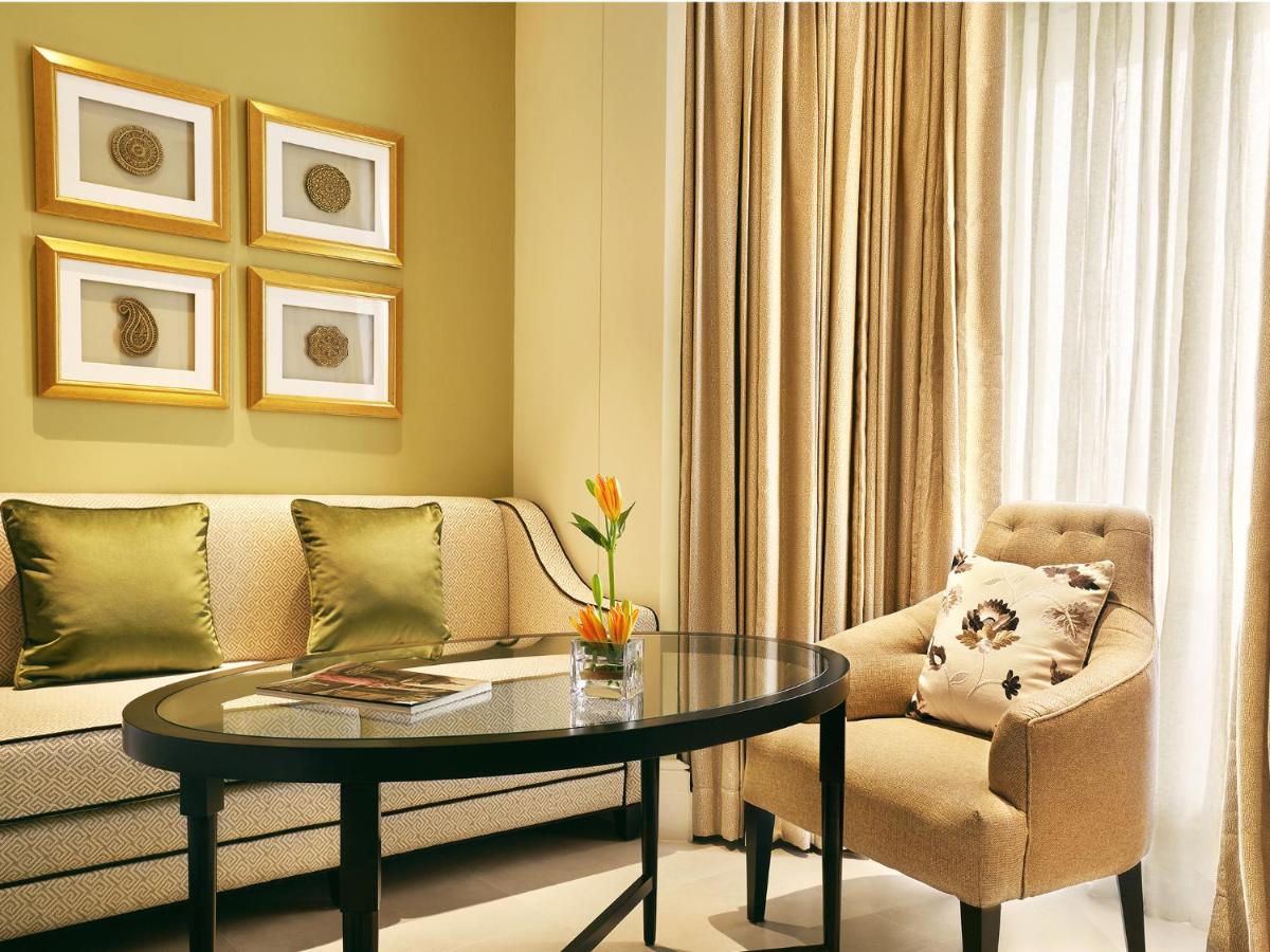 a living room with a couch and a table and a chair at Taj Connemara, Chennai in Chennai