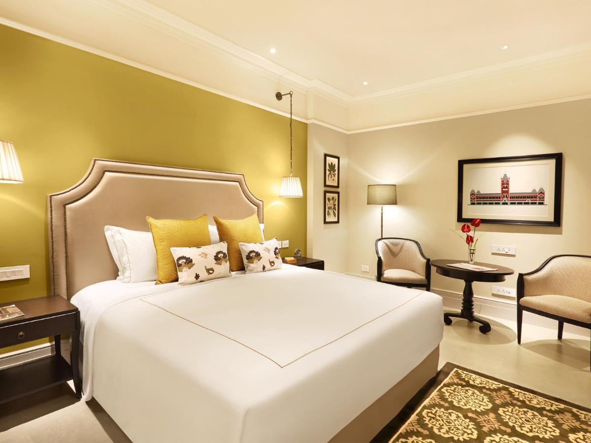a bedroom with a large white bed and a chair at Taj Connemara, Chennai in Chennai