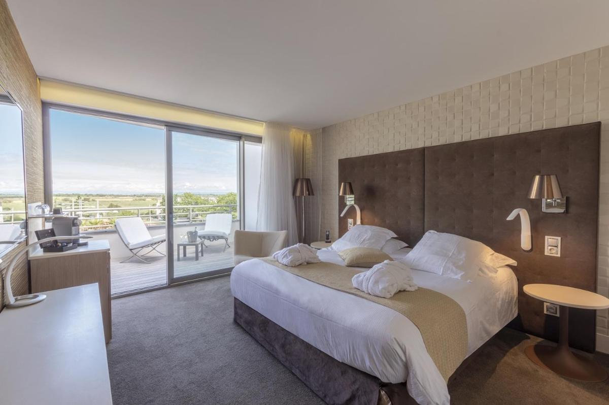 Un ou plusieurs lits dans un hébergement de l'établissement Oz'Inn Hôtel & Spa