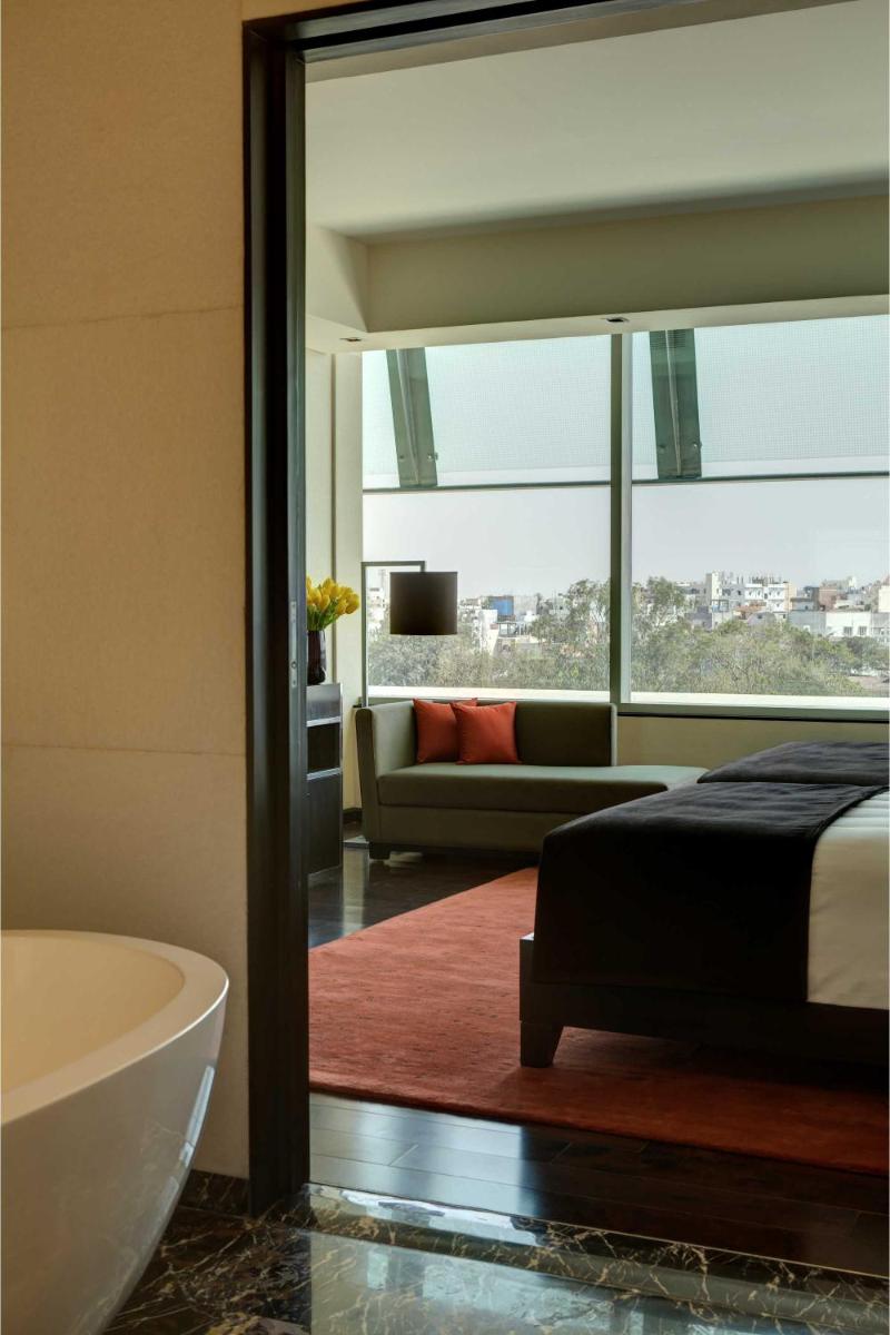 a bedroom with a tub and a bed and a couch at Park Hyatt Hotel and Residences, Hyderabad in Hyderabad