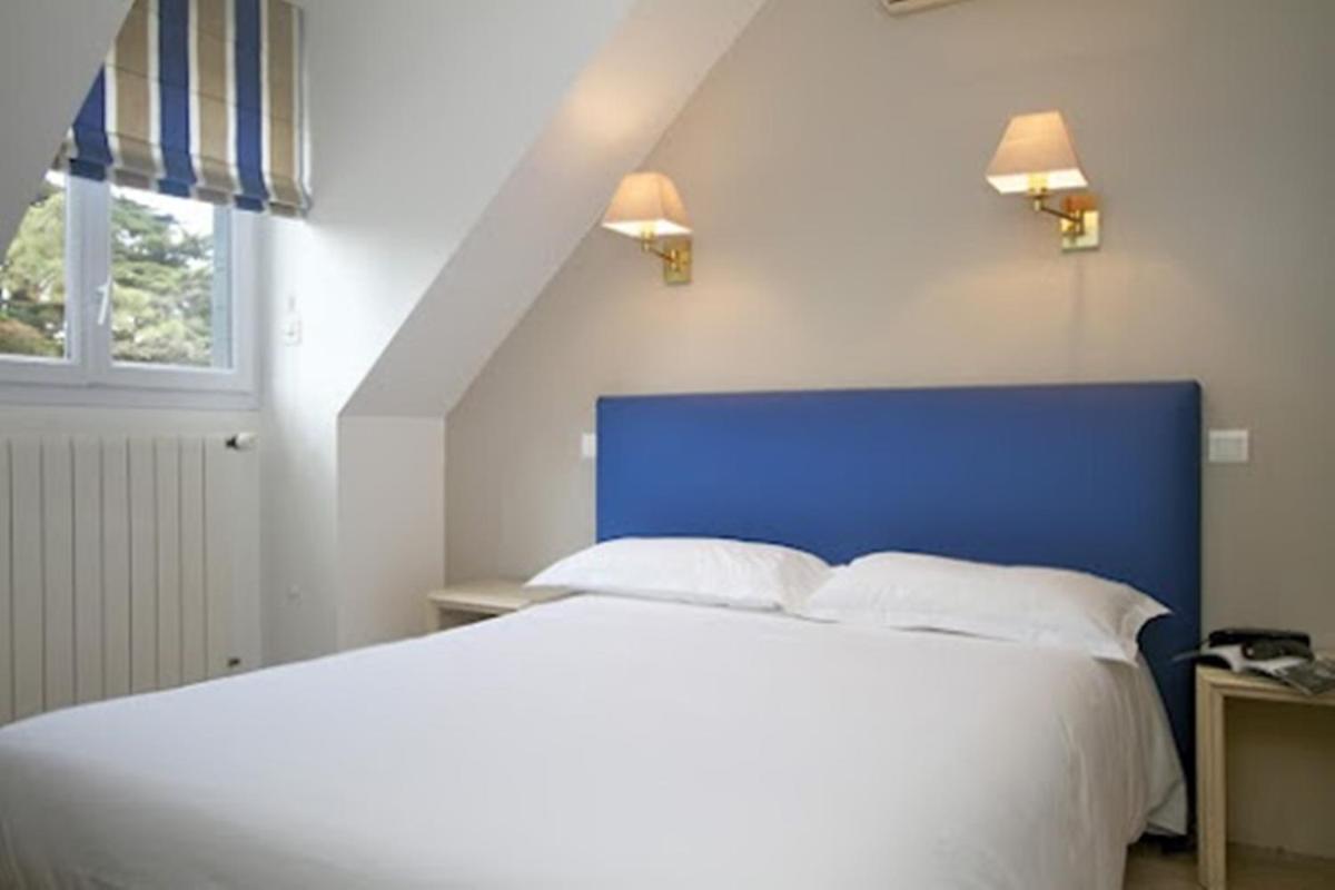 Un ou plusieurs lits dans un hébergement de l'établissement Hôtel Lutétia & Spa