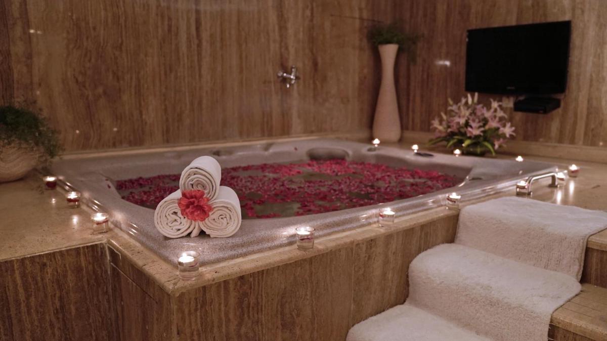 a bath tub with a pair of sandals in it at Jaypee Siddharth in New Delhi a bath tub with a pair of sandals in it at Jaypee Siddharth in New Delhi