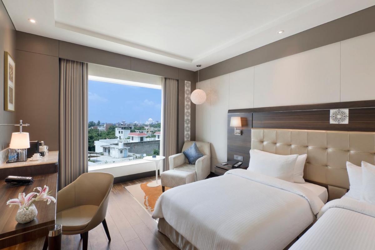 a hotel room with a bed and a window at Taj Agra in Agra