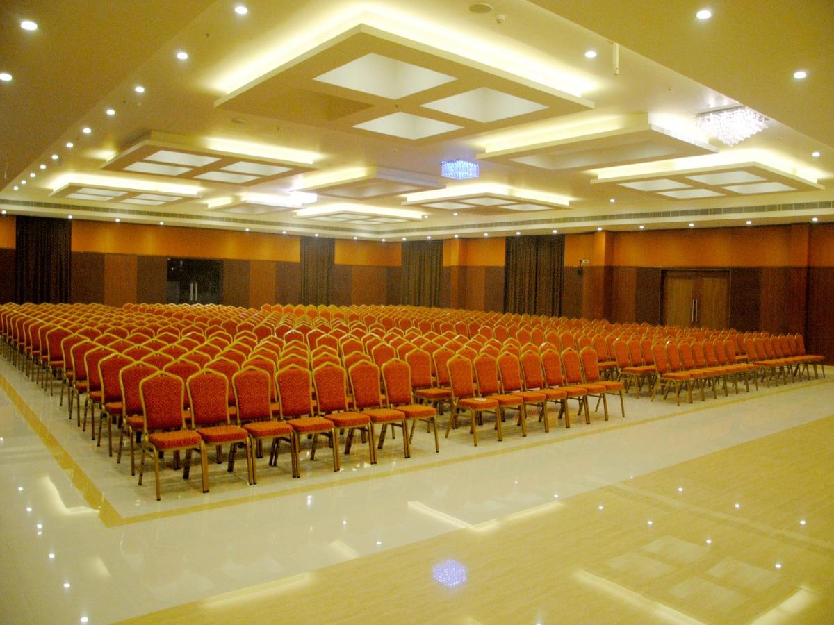 an empty auditorium with red chairs and a stage at Fortune Select Grand Ridge, Tirupati - Member ITC Hotels' Group in Tirupati