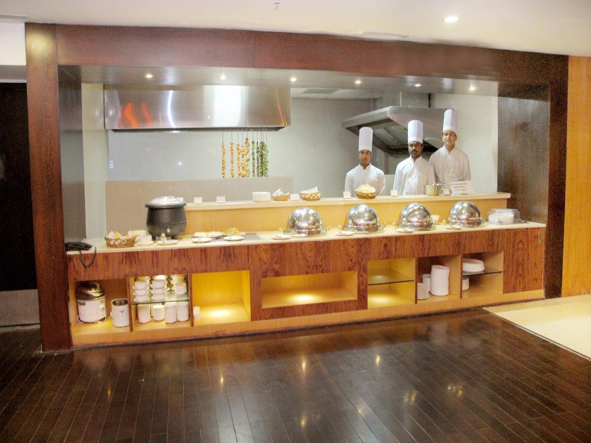 three chefs standing in a kitchen preparing food at Fortune Select Grand Ridge, Tirupati - Member ITC Hotels' Group in Tirupati