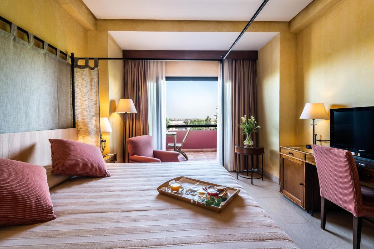 una habitación de hotel con una cama y un televisor en Intelier Airén, en Alcázar de San Juan