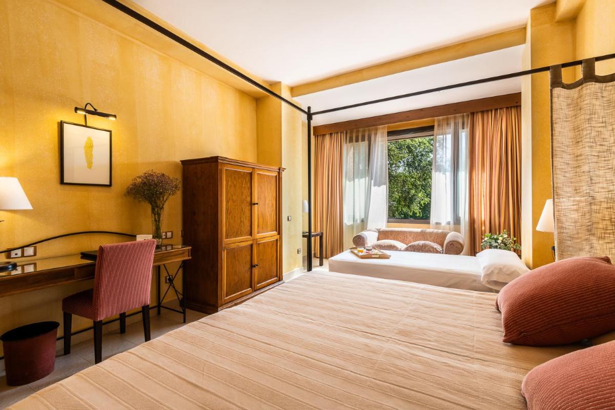 Un dormitorio con dos camas y un escritorio y una ventana. en Intelier Airén, en Alcázar de San Juan