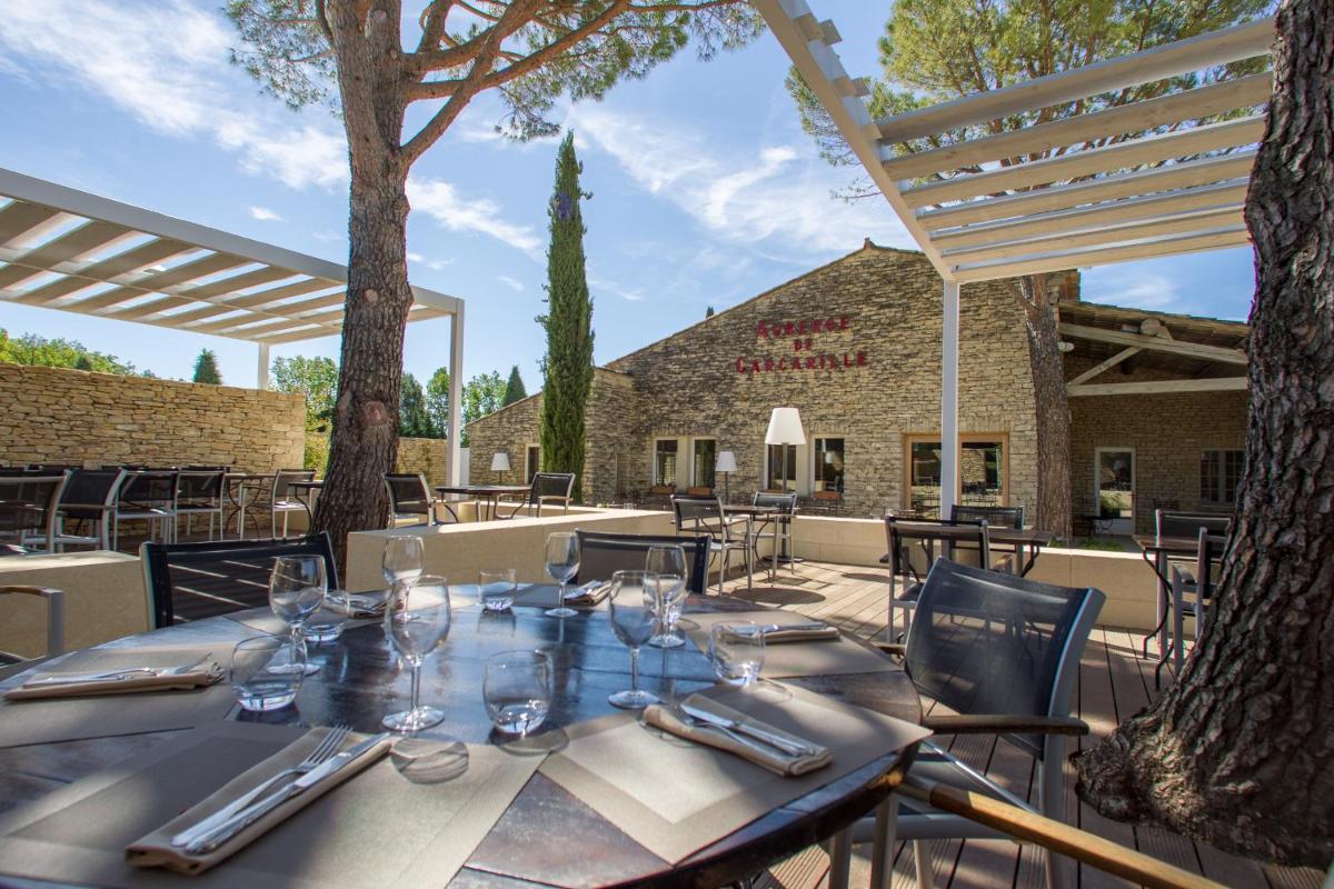 - une table avec des verres et des serviettes sur une terrasse dans l'établissement Hôtel Carcarille Restaurant Le C, à Gordes