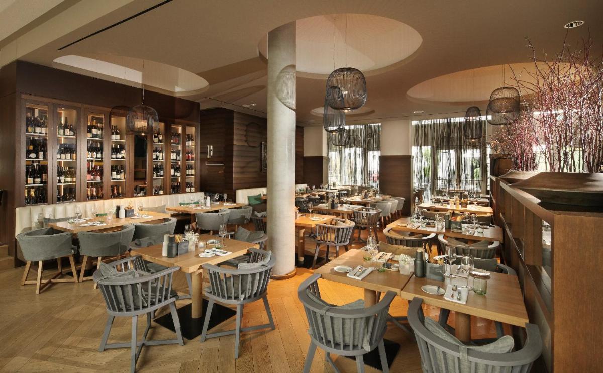 ein Esszimmer mit Holztischen und Stühlen in der Unterkunft Hotel Maximilian’s in Augsburg ein Esszimmer mit Holztischen und Stühlen in der Unterkunft Hotel Maximilian’s in Augsburg