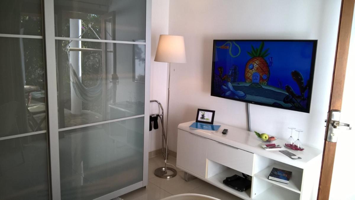 baño con ducha y TV en la pared en Birdcage Gay Men Resort and Lifestyle Hotel, en Playa del Inglés