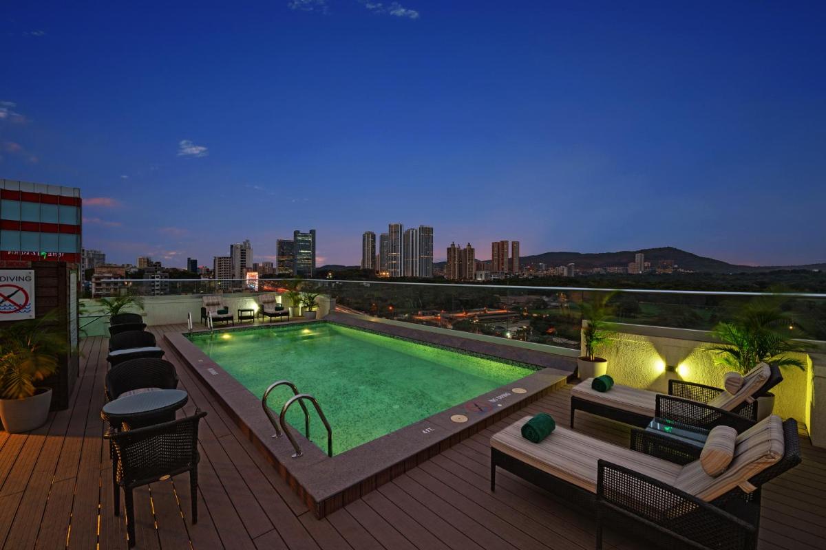 a rooftop deck with a swimming pool on a building at The Fern Mumbai, Goregaon, Series by Marriott in Mumbai a rooftop deck with a swimming pool on a building at The Fern Mumbai, Goregaon, Series by Marriott in Mumbai