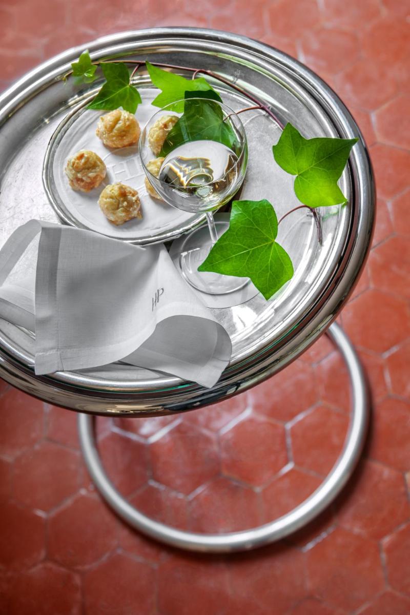 une assiette de nourriture sur une table avec des feuilles sur celle-ci dans l'établissement L'Hôtel Particulier, à Arles