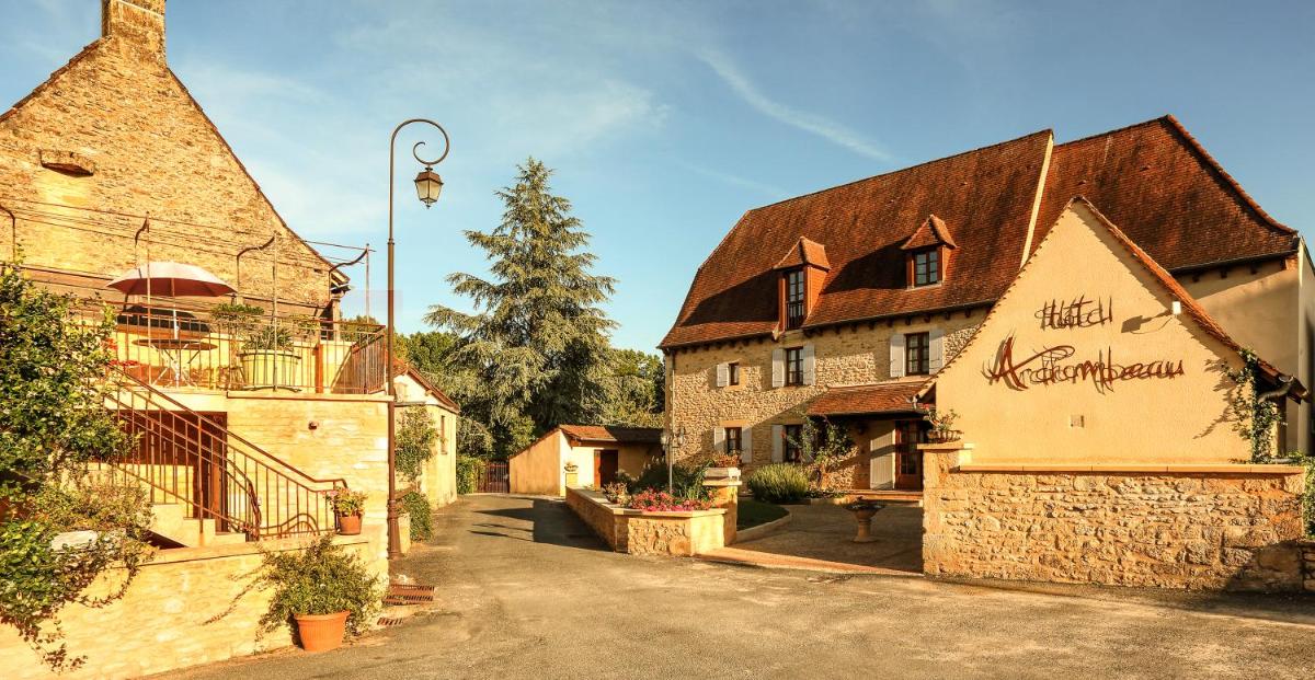 un bâtiment avec une enseigne sur le côté dans l'établissement Logis Hotel Archambeau, à Thonac