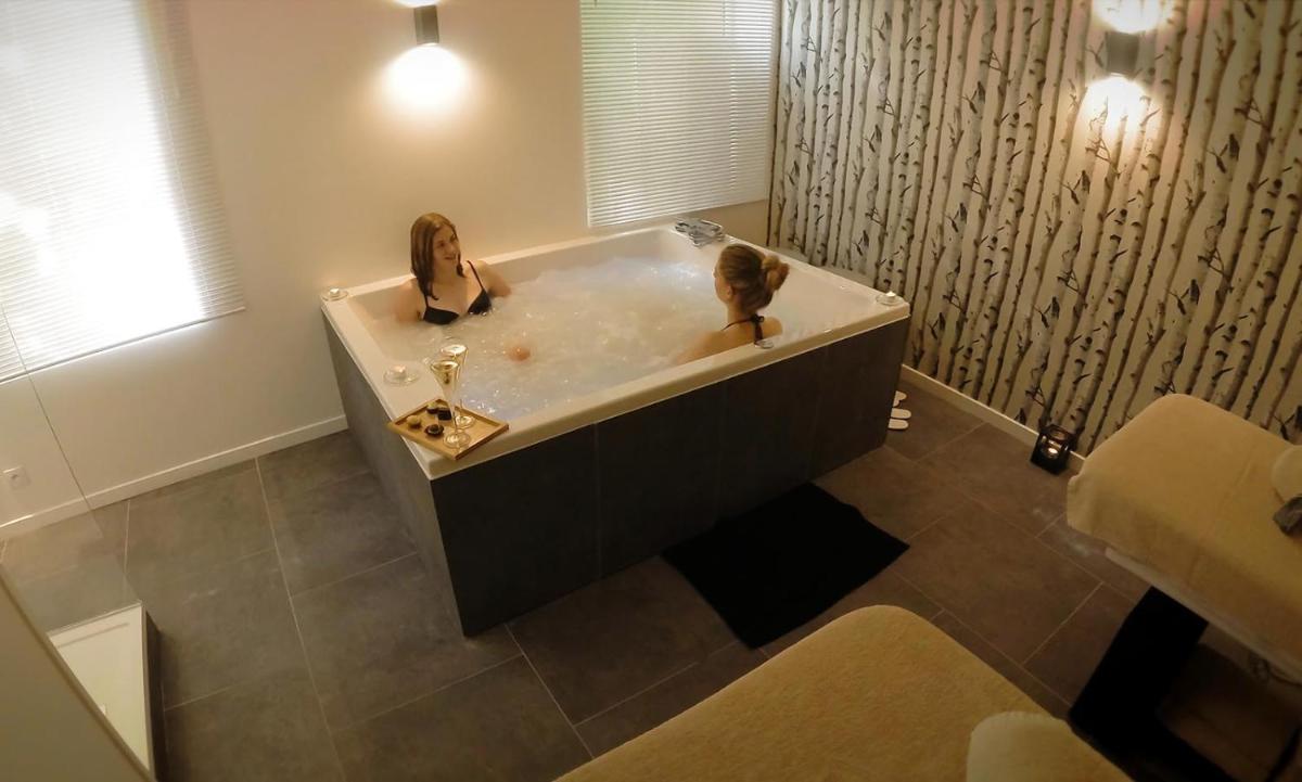 deux femmes assises dans une baignoire dans une salle de bain dans l'établissement Domaine de Joinville & Spa, à Eu 62 autres photos