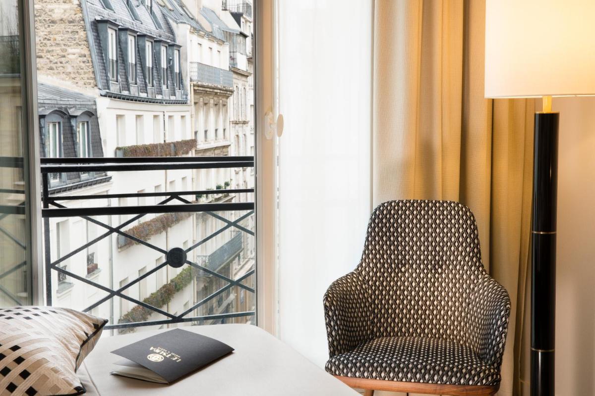 une chaise dans une pièce avec une fenêtre dans l'établissement Le Tsuba Hotel, à Paris