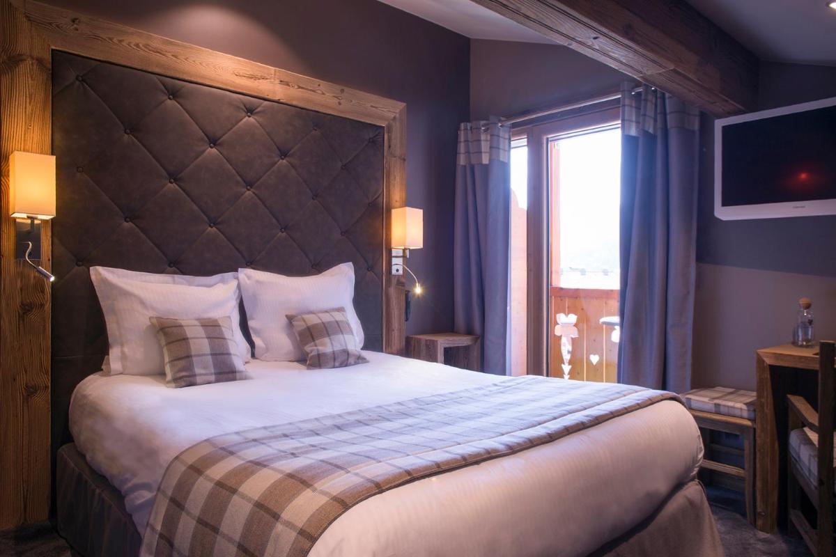 Un ou plusieurs lits dans un hébergement de l'établissement Les Gentianettes Hotel & Spa