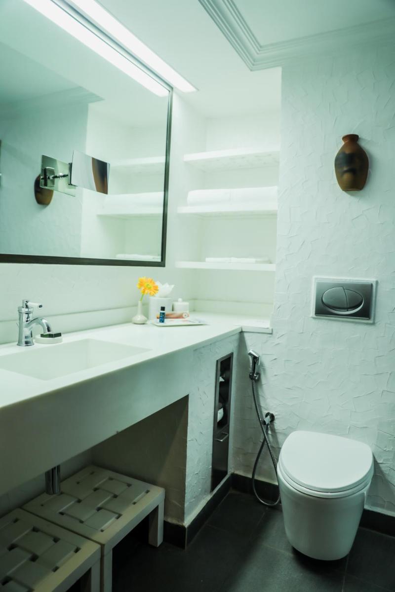 a bathroom with a sink and a toilet and a mirror at Sterlings Mac Hotel in Bengaluru