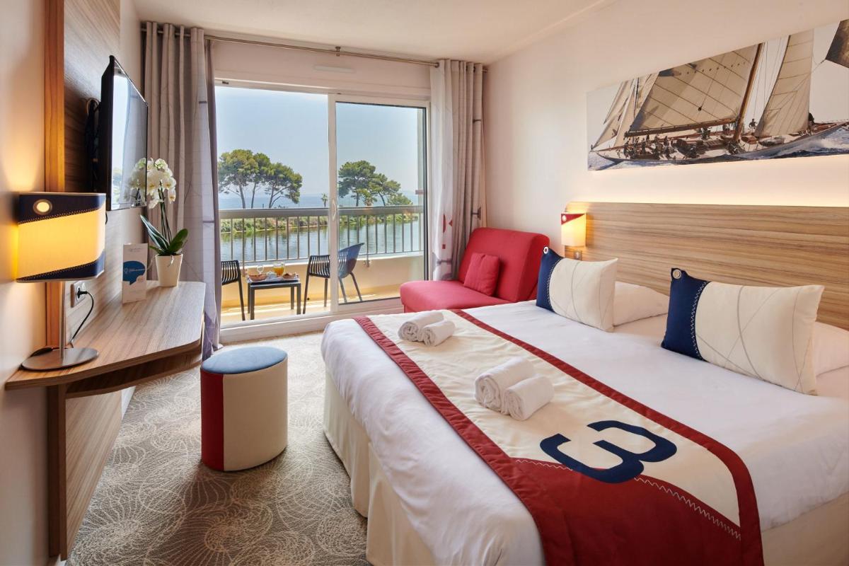 une chambre d'hôtel avec un grand lit et un balcon dans l'établissement Hotel Club Le Plein Sud Vacances Bleues, à Hyères