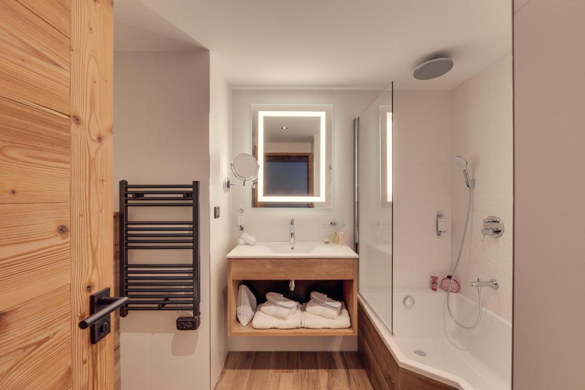 une salle de bain avec un lavabo, une douche et une baignoire dans l'établissement Hôtel Avancher, à Val dʼIsère