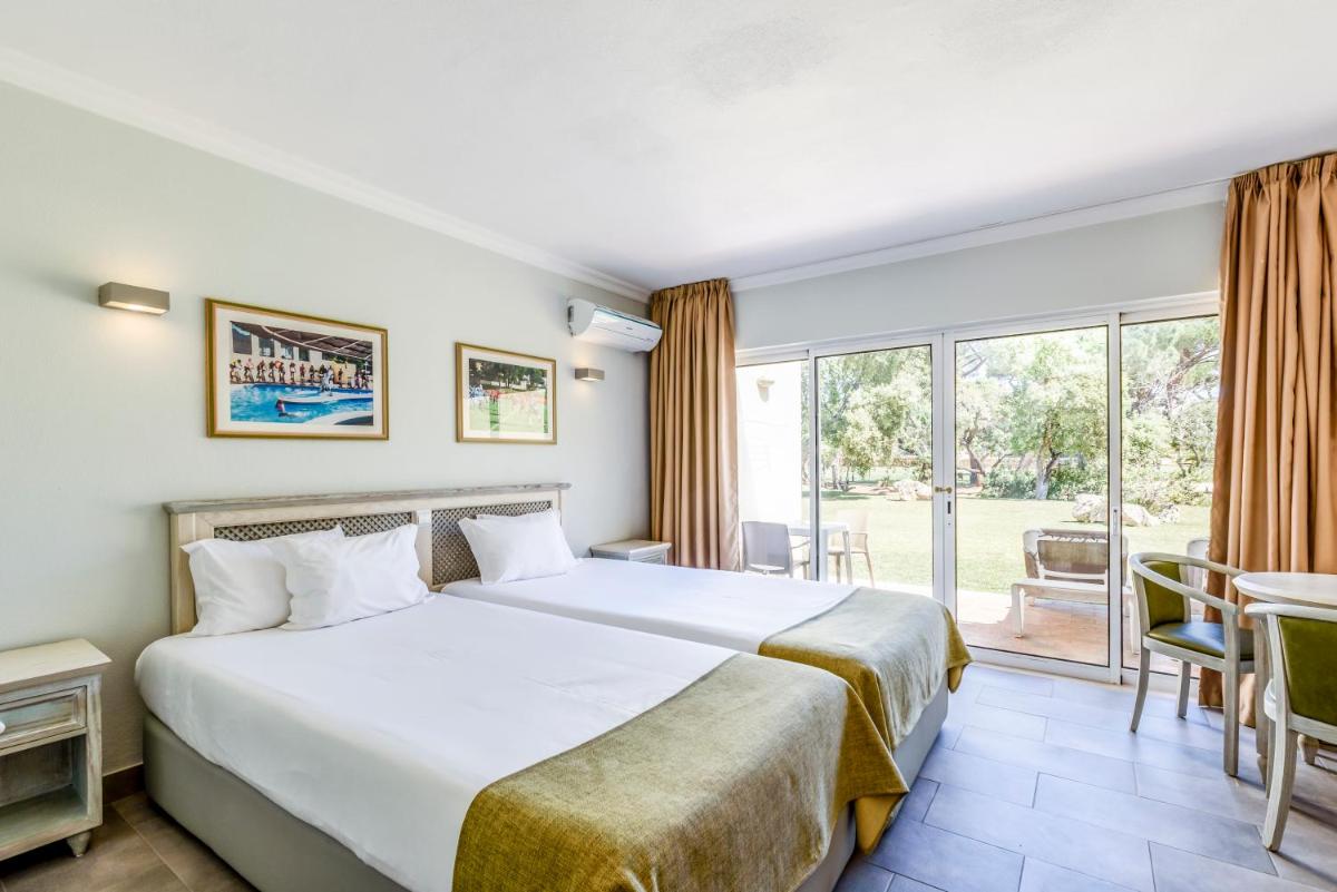 um quarto com uma cama grande e uma janela grande em Browns Sports Resort em Vilamoura