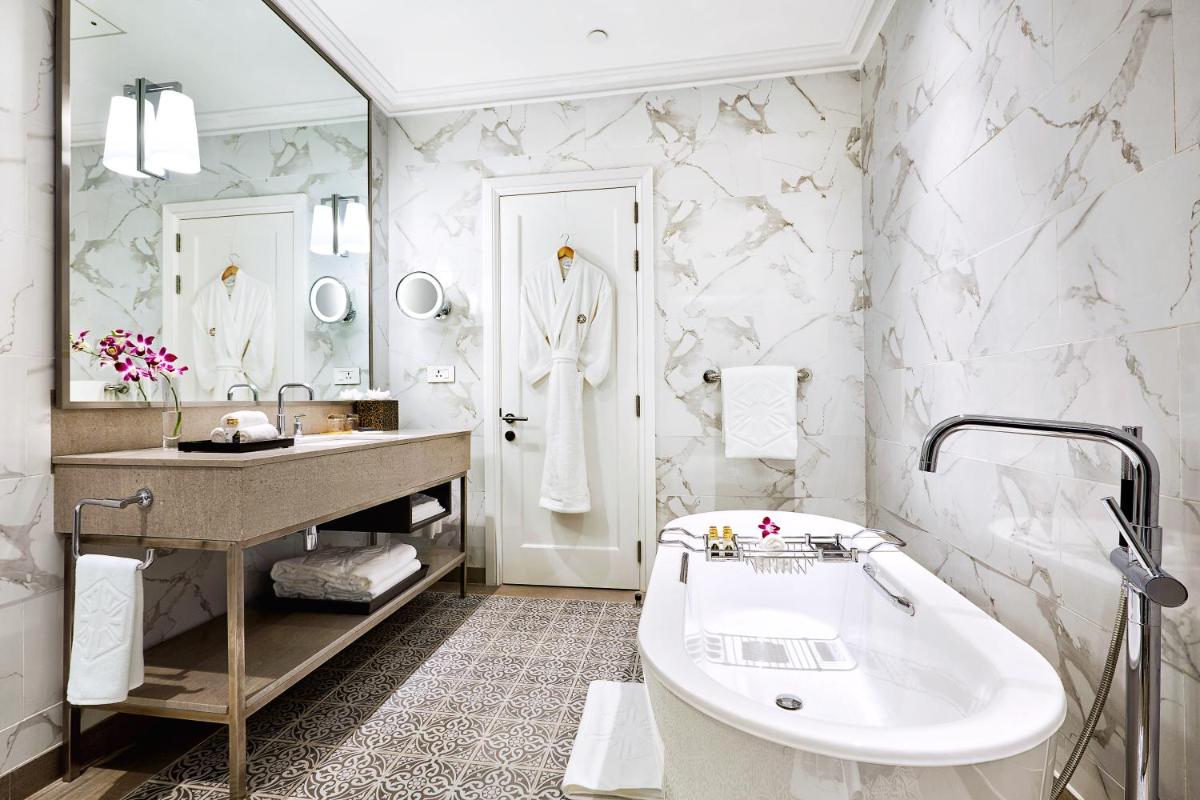 a white bathroom with a tub and a sink at Taj Connemara, Chennai in Chennai