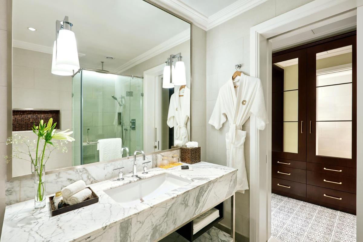 a bathroom with a sink and a large mirror at Taj Connemara, Chennai in Chennai