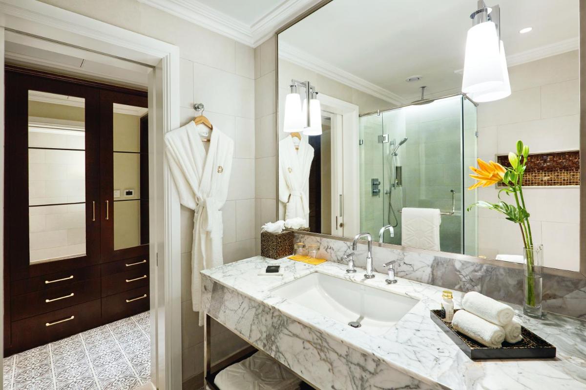 a bathroom with a sink and a large mirror at Taj Connemara, Chennai in Chennai