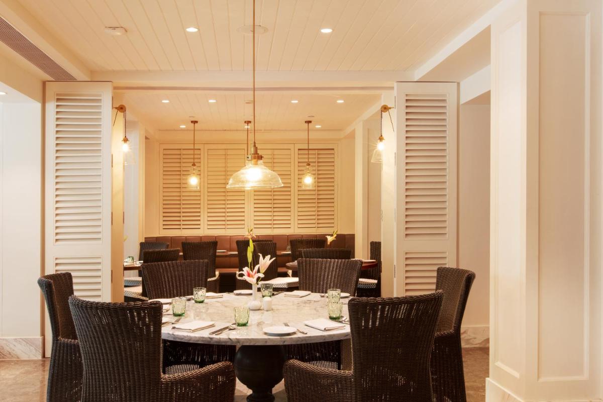a dining room with a table and chairs at Taj Connemara, Chennai in Chennai