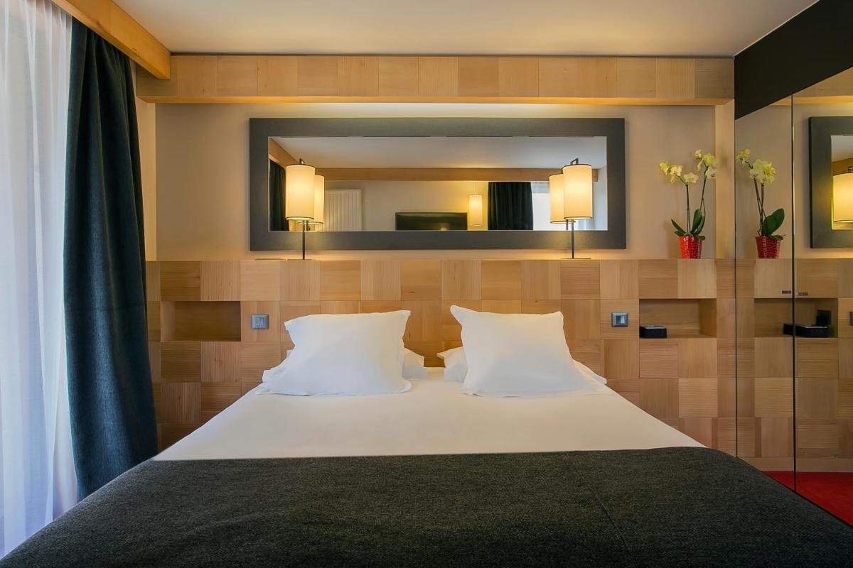 - une chambre avec un lit et un grand miroir dans l'établissement Excelsior Chamonix Hôtel & Spa, à Chamonix-Mont-Blanc